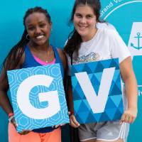 two students holding GV letters and posing in front of CAB backdrop at Laker Kickoff photo booth